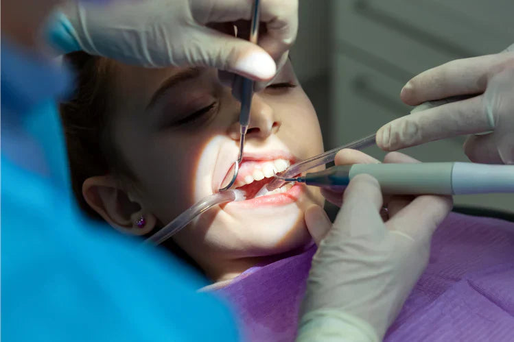Uma menina fazendo um procedimento odontológico no consultório de um dentista.