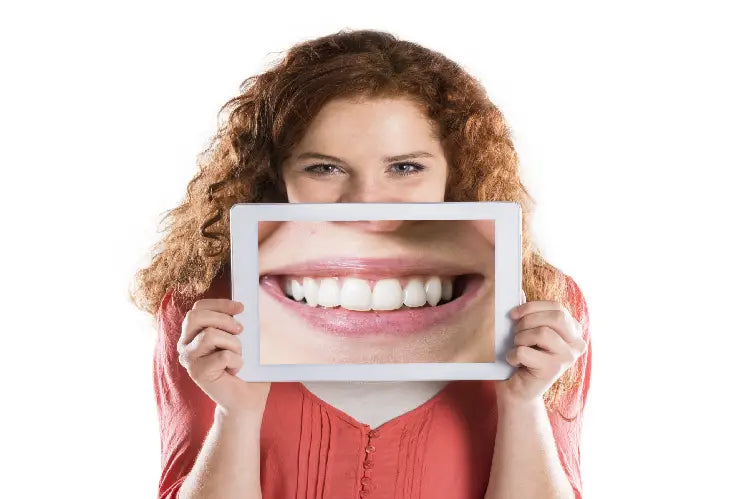 Uma imagem de uma menina a segurar uma imagem ampliada dos seus dentes