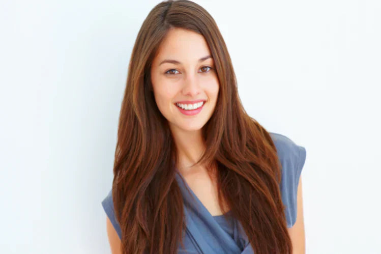 Uma jovem sorrindo para mostrar os dentes retos