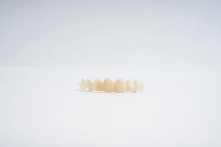 Facetas dentárias colocadas sobre uma superfície lisa.